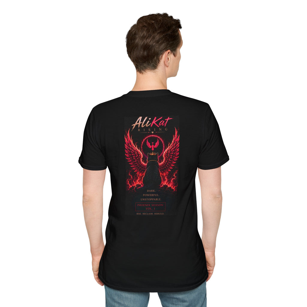 A man faces away, wearing the AliKat Rising Phoenix Vol. 1 Graphic Tee—a black shirt featuring a striking red graphic of a winged cat with lightning and "AliKat LLC" text, plus additional wording beneath the image. The background is plain white. Available in S, M, L, XL, and 2XL.